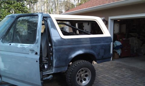 1995 Ford Bronco - The rear of a 1995 Ford Bronco is shown with the driver's side rear door open.