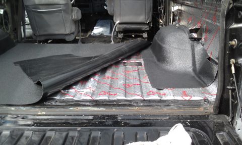 1995 Ford Bronco - Sound deadening insulation being installed in the rear interior of a vehicle.
