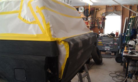1995 Ford Bronco - A vehicle is undergoing bodywork and preparation for painting in a garage setting.