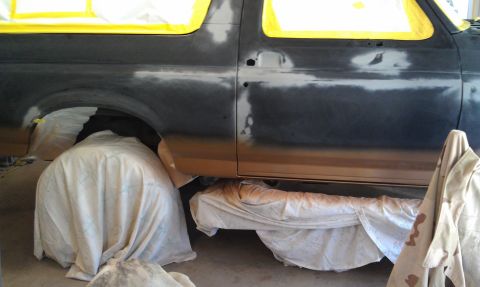 1995 Ford Bronco - This 1995 Ford Bronco is being prepped for a new paint job, with masking tape covering the windows and body panels covered in primer.