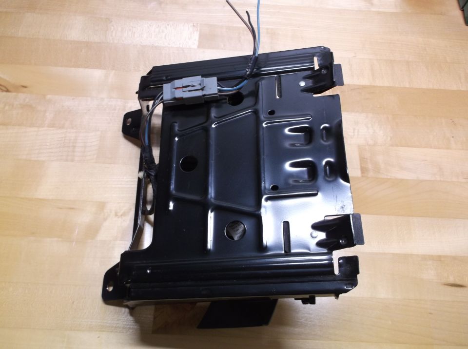 Black metal seat frame with wiring harness and connector, viewed from the side