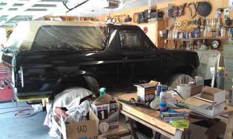 1995 Ford Bronco - A black Ford Bronco is being prepped for painting in a cluttered garage environment.