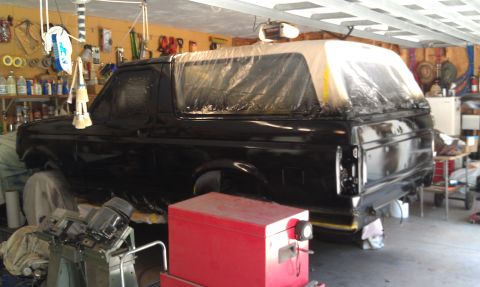 1995 Ford Bronco - Ford Bronco undergoing paint work in a garage setting.