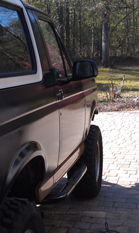 1995 Ford Bronco - Side view of a 1995 Ford Bronco parked on a brick driveway.