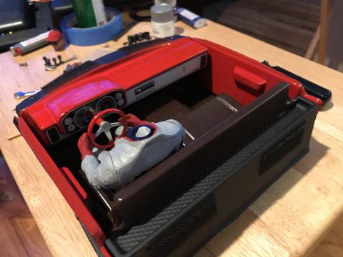 1989 Ford Bronco - A model car's interior is shown, complete with a steering wheel and a figure in the driver's seat.