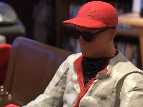 1989 Ford Bronco - A figure in a red cap and sunglasses is depicted, with a white jacket trimmed in red.