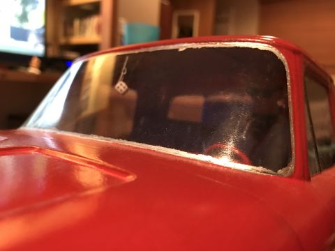 1989 Ford Bronco - Close-up of a red toy car's interior, a dangling pair of dice.