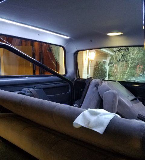 1995 Ford Bronco - The rear seats of the vehicle have been removed, revealing the interior structure and a roll bar.