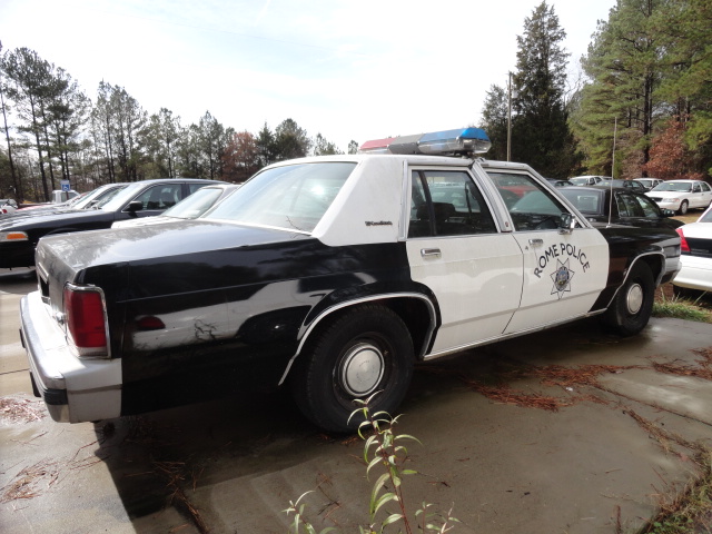 Black and white 1988 Ford Crown Victoria LTD police car with 'ROME POLICE' text and a light bar