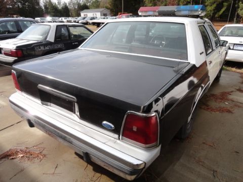 1988 Ford Crown Victoria LTD - Rear view of a 1988 Ford Crown Victoria LTD police car, showing its distinctive taillights and chrome bumper.