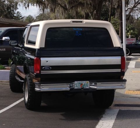 1995 Ford Bronco - Rear view of a lifted 1990s Ford Bronco with a two-tone paint scheme and Florida plates.