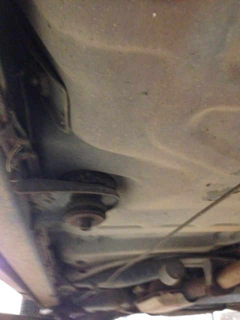 1988 Ford Crown Victoria LTD - A close-up view of the undercarriage of a vehicle, revealing suspension parts and exhaust system.