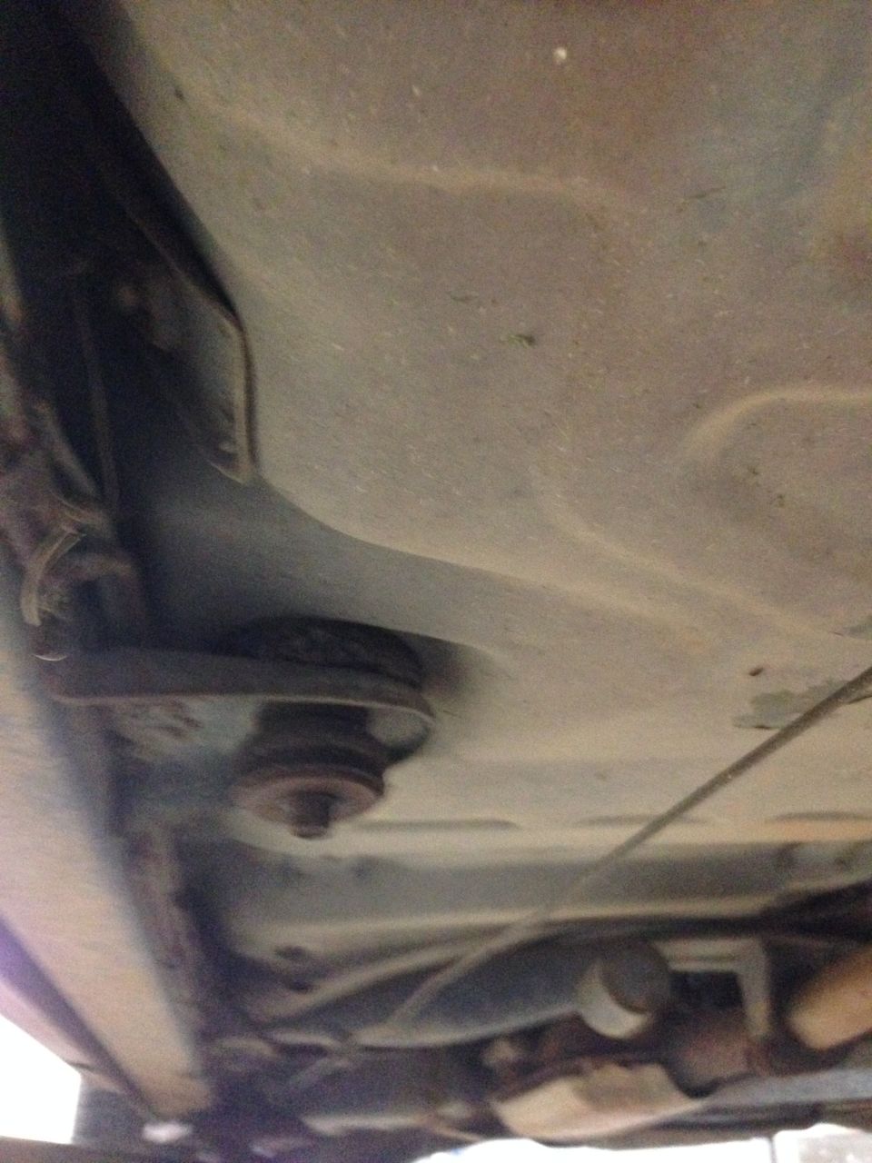 Underside view of a car, showing some suspension components and exhaust pipe
