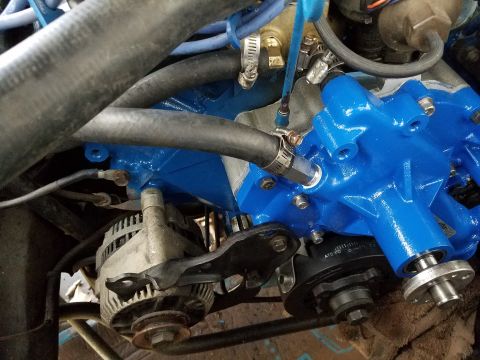 1976 Ford Ranchero - Engine bay detail showing an alternator and a freshly painted blue component with various hoses attached.
