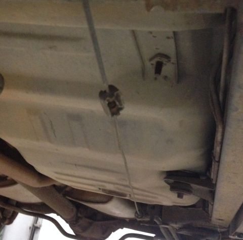 1988 Ford Crown Victoria LTD - The underside of a vehicle, focusing on the fuel tank and exhaust components.