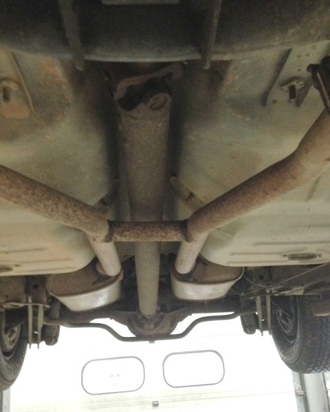1988 Ford Crown Victoria LTD - The underside of a vehicle is shown, revealing its exhaust system and drivetrain components.