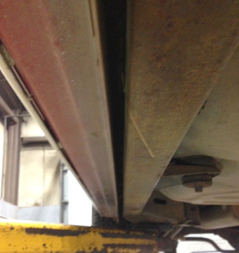 1988 Ford Crown Victoria LTD - Close-up of the undercarriage of a vehicle, revealing structural components and signs of wear.
