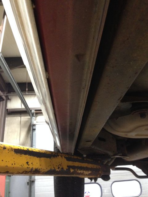 1988 Ford Crown Victoria LTD - Close-up of the undercarriage of a vehicle, focusing on the rocker panel and frame components.