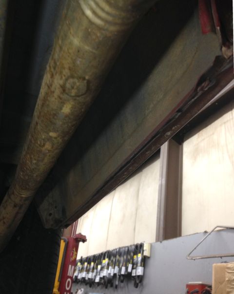 1988 Ford Crown Victoria LTD - The undercarriage of a vehicle, with visible rust on the frame and exhaust system.