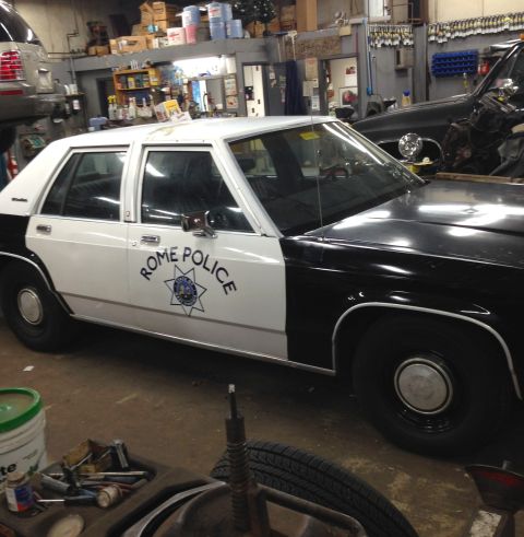 1988 Ford Crown Victoria LTD - Side view of a 1988 Ford Crown Victoria LTD police car parked inside a garage.