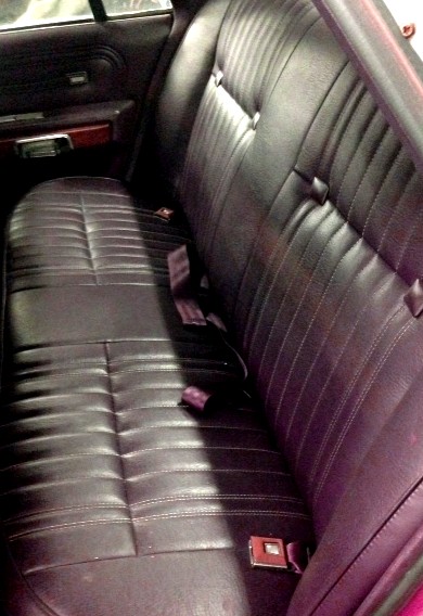 1988 Ford Crown Victoria LTD - The interior of a 1988 Ford Crown Victoria LTD shows a dark-colored rear bench seat with seat belts.