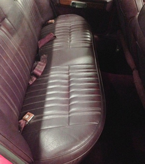 1988 Ford Crown Victoria LTD - The interior of a car shows the rear bench seat with seatbelts.