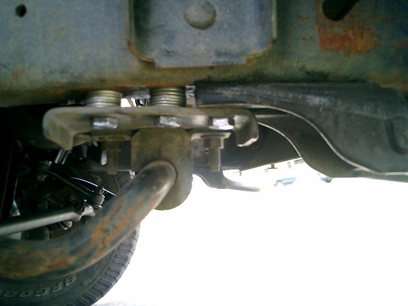 Underbody view of a tow hook assembly with bolts and springs attached to a frame
