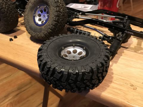 1989 Ford Bronco - Close-up of RC car parts, including tires and suspension, laid out on a table.