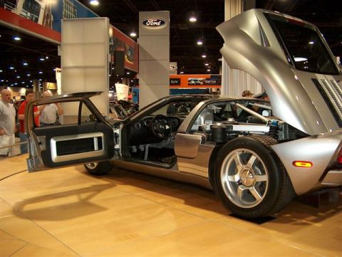 2001 Ford Crown Victoria - A silver Ford GT is displayed with its doors and hood open, revealing its interior and engine bay at an auto show.