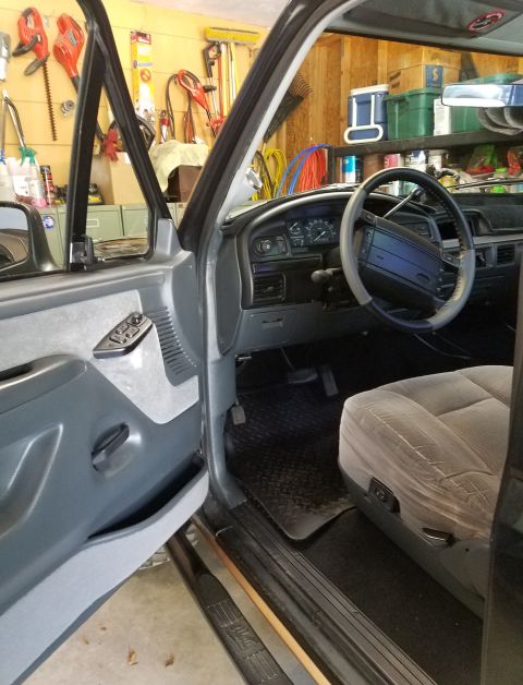 1995 Ford Bronco - The interior of a 1992 Ford Bronco is visible, with the driver's side door open.