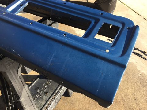 1978 Ford Bronco - Blue metal panel with multiple holes and rectangular openings, possibly a car part.