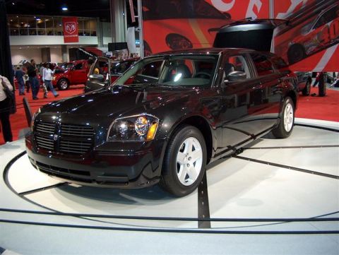 2001 Ford Crown Victoria - A black Dodge Magnum wagon is displayed at an auto show, with other cars and signage visible.