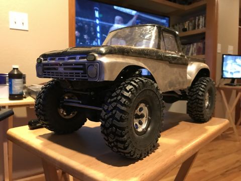 1989 Ford Bronco - This RC truck has a custom body and large off-road tires, sitting on a table indoors.
