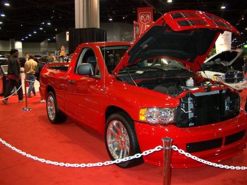 2001 Ford Crown Victoria - A red Dodge Ram SRT-10 pickup truck is displayed with its hood open at an auto show.