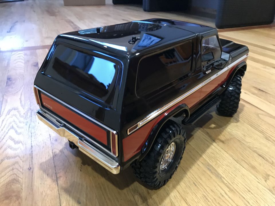 Black and orange Ford Bronco rear 3/4 view on wood floor