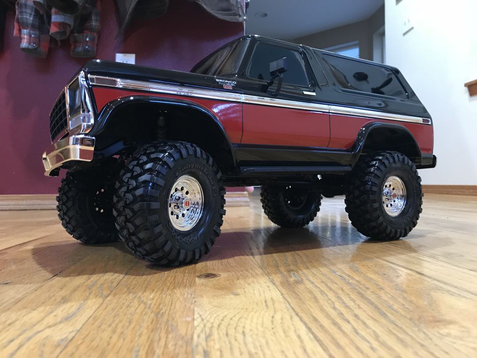 RC Ford Bronco with red and black paint, chrome trim, and large off-road tires.