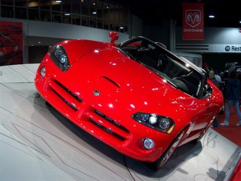 2001 Ford Crown Victoria - A bright red Dodge Viper is showcased at an auto show, with a Dodge banner visible in the background.