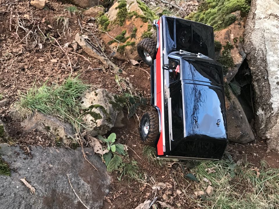 Black and red RC truck on rocky terrain