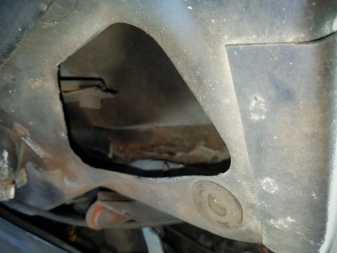 1994 Ford Bronco - Photograph of a vehicle frame with an access cut-out, not a technical document.
