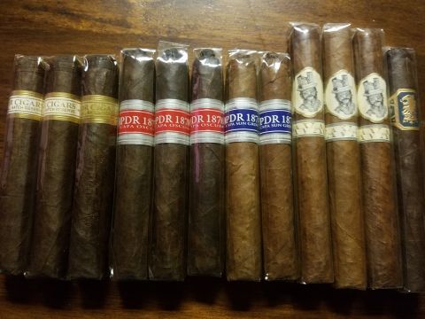 2018 Ford Bronco - A collection of cigars is laid out on a wooden surface. The cigars are individually wrapped in cellophane and have various labels.
