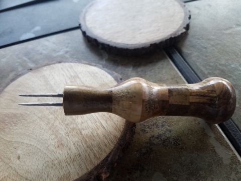 2018 Ford Bronco - A close-up shot of a wooden-handled ice pick with two metal prongs, resting on a textured surface next to wooden coasters.