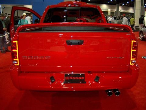 2001 Ford Crown Victoria - A red Dodge pickup truck is displayed at an auto show with its rear facing the camera.