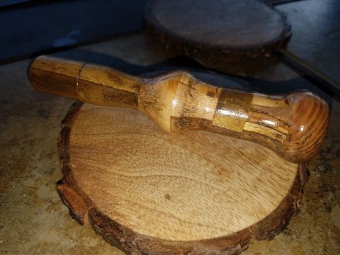 2018 Ford Bronco - A wooden pestle rests on a wooden slice with bark on the edge. The pestle is made of various pieces of wood joined together and has a gloss…