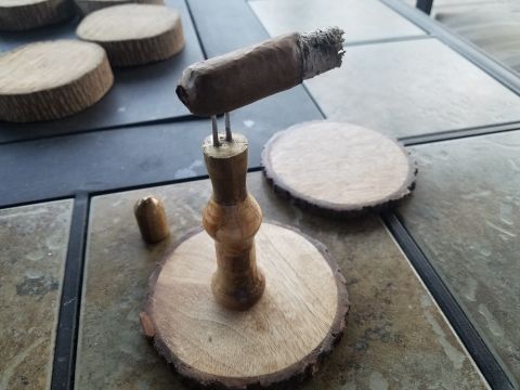 2018 Ford Bronco - A lit cigar rests on a wooden stand, which is placed on a wooden coaster. Several other wooden coasters are visible in the background.