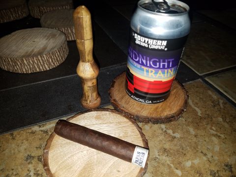 2018 Ford Bronco - A cigar rests on a wooden coaster next to a can of Southern Brewing Company Midnight Train porter and a wooden tamper. Several other wooden…