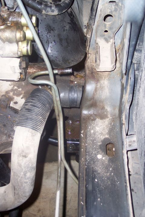 1995 Ford Bronco - This image shows a close-up view of the engine bay of a 1995 Ford Bronco, focusing on hydraulic lines and hoses near the firewall. The area…