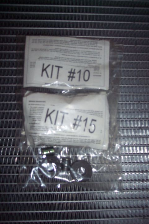 1995 Ford Bronco - Two plastic bags containing kits labeled "KIT #10" and "KIT #15" are shown resting on a metal grid. A few small metal parts are visible ins…