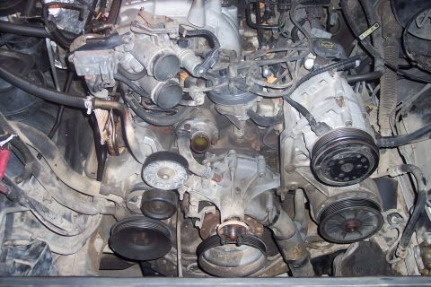 1995 Ford Bronco - A close-up, overhead view of a V8 engine bay, likely from a 1990s Ford truck or SUV, showing the alternator, power steering pump, and air c…