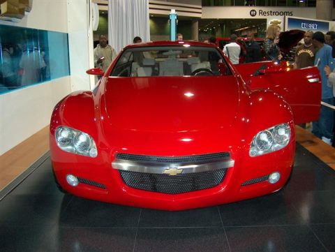 2001 Ford Crown Victoria - A red Chevrolet concept car is displayed with its doors open at an auto show.