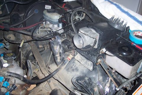 1995 Ford Bronco - This is a close-up view of the engine bay of a 1995 Ford Bronco, showing various components including the brake master cylinder, air intake…